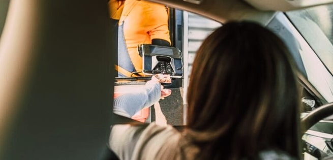 a lady paying thru a drive-thru window