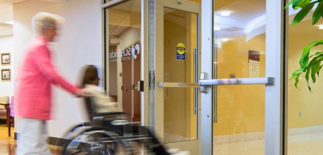 a lady on a wheel chair passing through an automatic door