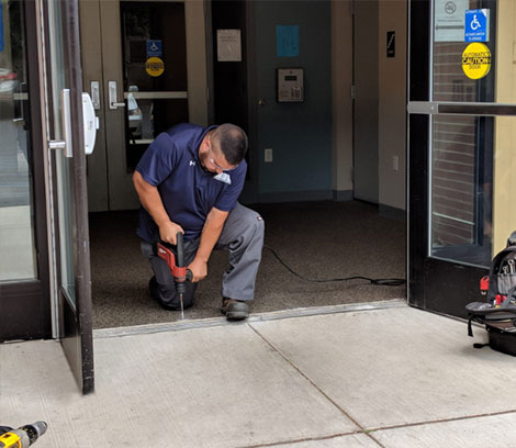 A man is providing door service using a drill